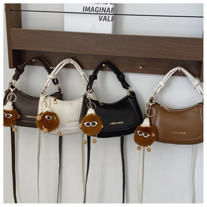Minimalist leather handbags in four colors with cute monster charms on a wall rack