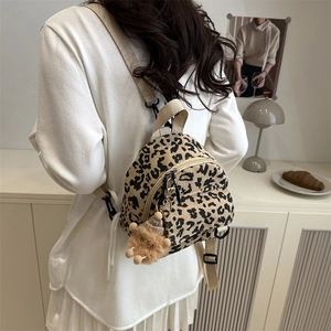 Trendy leopard print corduroy crossbody bag shown on model in cozy home setting