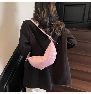 Pink vintage wax leather crescent bag with stitched segments shown on a model's back