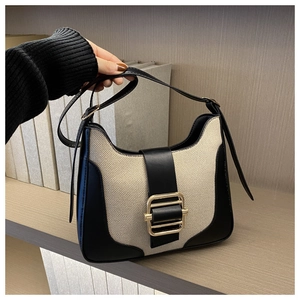 Détail du sac patchwork en toile et cuir avec boucle dorée et bandoulière réglable
