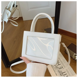 Detail of white PVC crossbody bag with transparent window and leather texture finish