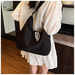 Detail of black nylon tote bag with white braided rope decor and minimalist design