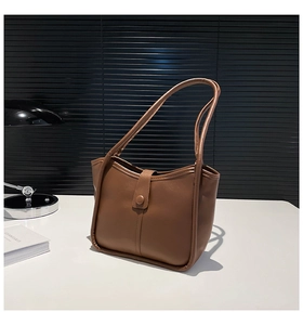 Detailed view of dark coffee PU leather tote bag with trapezoidal design and magnetic buckle