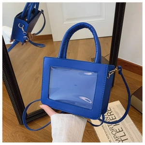 Macro shot of the royal blue PVC panel and gold hardware detail on this crossbody bag