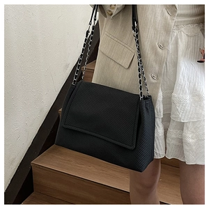 Detail of black chain strap tote bag featuring textured leather and silver hardware