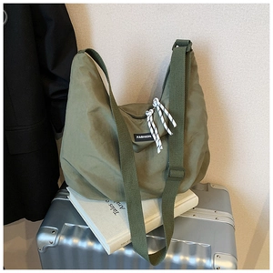 Macro shot of army green nylon bag featuring fashion label and woven rope zipper pull