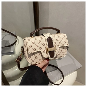 Detail of floral print handbag with asymmetric flap and golden metal clasp closure