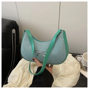Close-up of mint green hobo bag with sparkling rhinestones and a metal bow detail