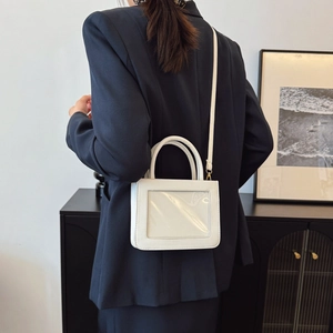 White PVC ita bag with transparent window and crossbody strap on a blazer model