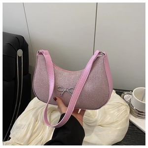 Detail of pink glitter shoulder bag with silver bow metallic charm and textured finish