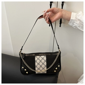 Close-up of black leather bag with beige jacquard stitching and gold chain detail