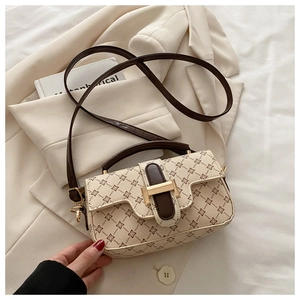 Detail of vintage clover print handbag with gold buckle closure and brown strap