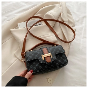 Detail view of a retro geometric print crossbody bag with brown leather accents and hardware