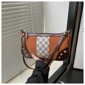 Detail of vintage patchwork shoulder bag with clover strap and gold rivet accents
