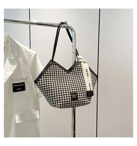 Detail of houndstooth tote bag featuring V-shape opening and decorative ribbon