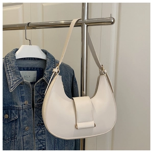 Close-up of white crescent shoulder bag with smooth leather finish and belt buckle detail