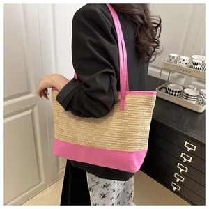 Detail of woven tote bag featuring bright pink leather trim and long shoulder straps