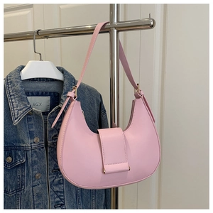 Detail of pink crescent bag with matte leather texture and decorative strap buckle