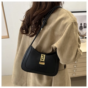 Dettaglio borsa hobo minimalista in pelle nera con fibbia dorata e tracolla con nodo