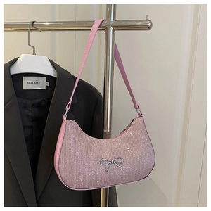 Detail of pink sequin shoulder bag with elegant silver metallic bow and curved design