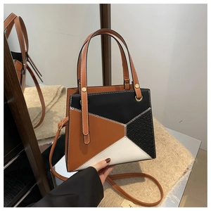 Detail der geometrischen Leder-Patchwork-Nähte und Krokostruktur auf der Handtasche