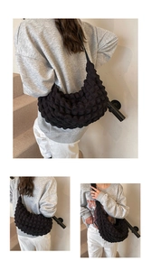 Detail of black crescent tote bag featuring unique bubble pleated texture and nylon fabric