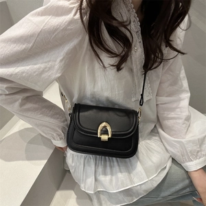 Classic black leather saddle bag with gold horse-bit buckle and slim shoulder strap