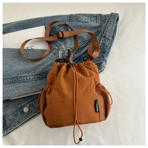 Detail der Nylon-Beuteltasche in Karamell mit orangefarbener Netztasche und Kordelzug