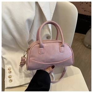 Close-up of pink leather handbag with fashion embossing and adjustable crossbody strap