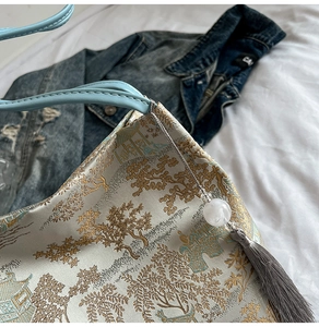 Detail of traditional Chinese jacquard tote bag featuring pine motifs and silk tassels