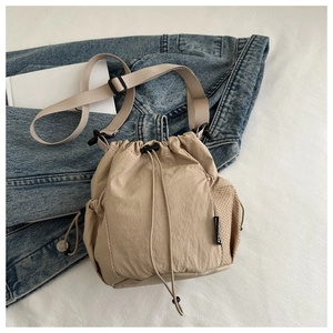 Detail der khakifarbenen Nylon-Beuteltasche mit Netzseitentasche und schwarzem Gurt
