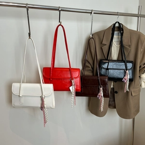 Minimalist vintage shoulder bags in cream, red, brown, and black with pendants