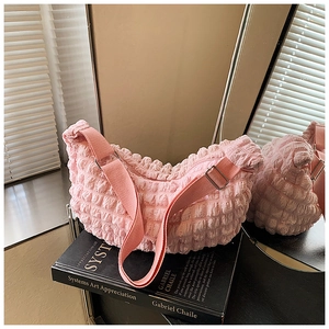 Detailed view of pink bubble cloud bag texture with adjustable fabric shoulder strap