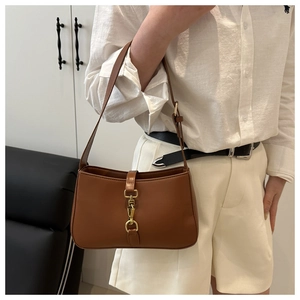 Détail du sac sous le bras en cuir marron rétro avec boucle métallique dorée distinctive