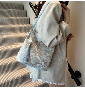 Detail of the blue landscape print and hanging tassel on a chic Chinese style tote bag