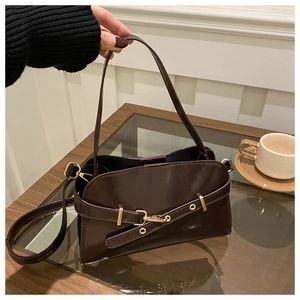 Detailansicht der dunkelbraunen Glanz-Muscheltasche mit goldener Schließe und Riemen