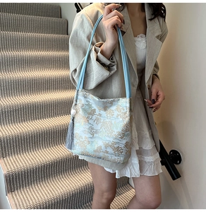 Detail of light blue jacquard shoulder bag with traditional Chinese landscape and tassel