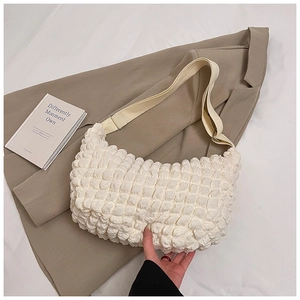 Close-up of cream popcorn texture fabric and adjustable strap on a shoulder bag