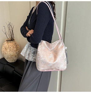 Detail of light pink shoulder bag with traditional landscape print and grey silk tassel