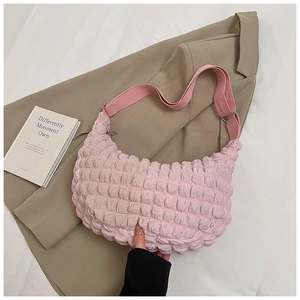 Pink popcorn texture crescent shoulder bag with woven strap on a soft beige background