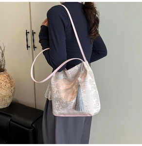 Detail of pink jacquard bucket bag with landscape patterns and decorative silk tassel
