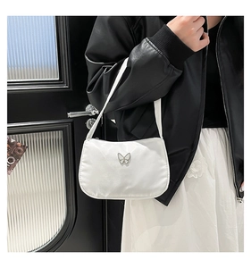 Detail of white nylon underarm bag with a silver butterfly metal buckle on the strap