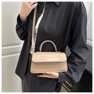 Detail of light beige crossbody bag featuring woven texture and smooth leather finish