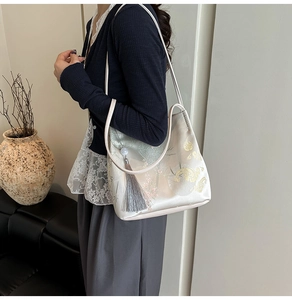 Detail of floral print shoulder bag with elegant grey tassel in a Zen-style setting