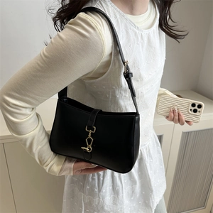 Sac sous le bras noir en forme de croissant avec boucle dorée pour un look de printemps