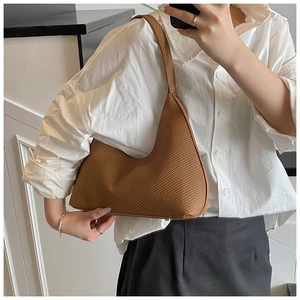 Detailed view of brown woven texture hobo bag with protective metal bottom studs