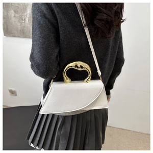 White leather handbag with unique gold metal handle shown on shoulder with dark sweater