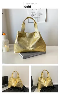 Detail of gold metallic tote bag with crocodile pattern texture in lifestyle setting