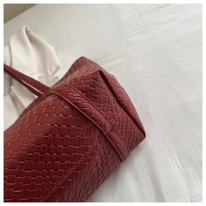 Detail shot of the red woven leather texture and fine stitching on this large tote bag