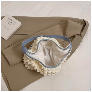 Detail of waffle popcorn texture shoulder bag with light blue leather trim and lining